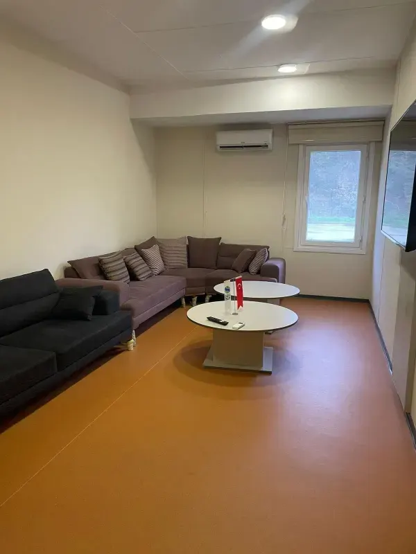 Shared living and lounge area containing comfortable sofas and screen