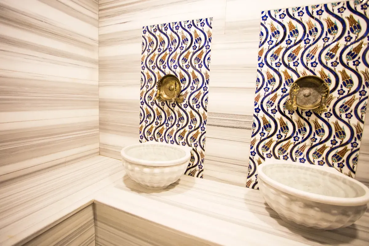 Shared bathroom with double sinks and decorative tiles